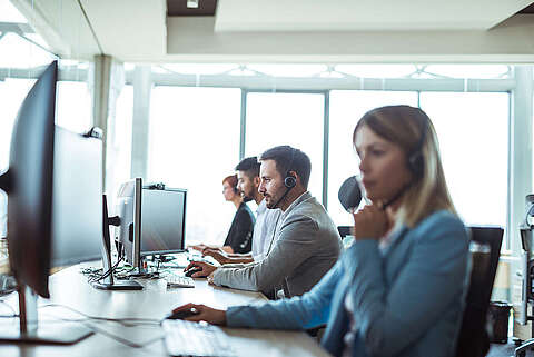 DMS-Service Servicemitarbeiter sitzen in einem Büro und telefonieren mit Kunden